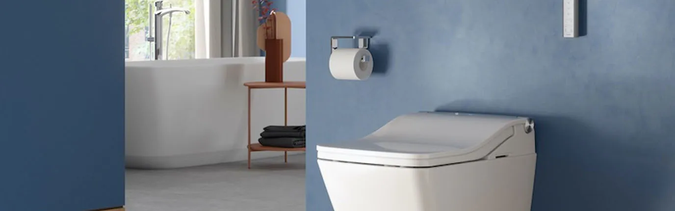 Ein modernes Badezimmer mit blauen Wänden zeigt eine elegante Toilette mit integriertem Bidet und einem darüber befestigten Toilettenpapierhalter.