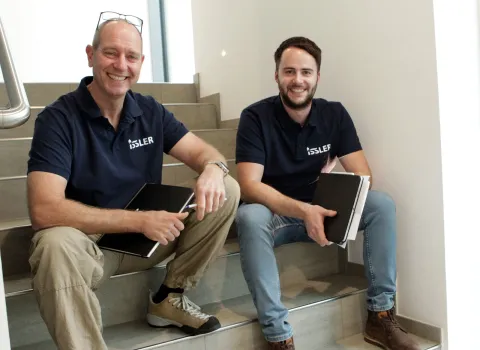 Geschäftsleitung Gerhard Wilschütz und Hannes Rütschlin sitzen auf der Treppe