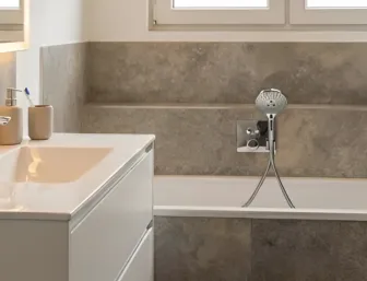 Zeiltos elegantes Bad mit Badewanne, offenem Stauraum, Handtuchheizung und Toilette in klarer Raumstruktur
